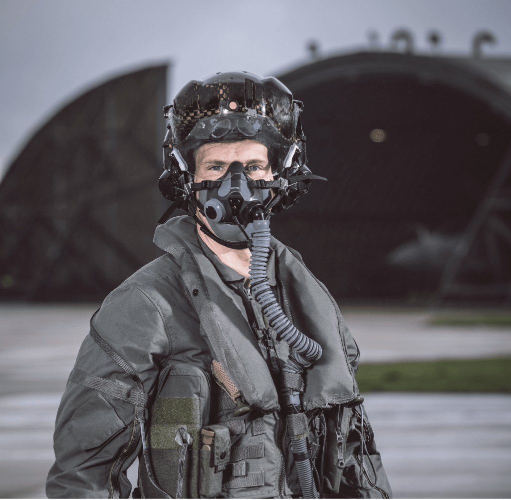 F-35 pilot in full protective clothing outside an aircraft shelter